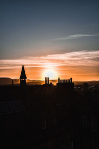 Silhouette buildings against sky during sunset