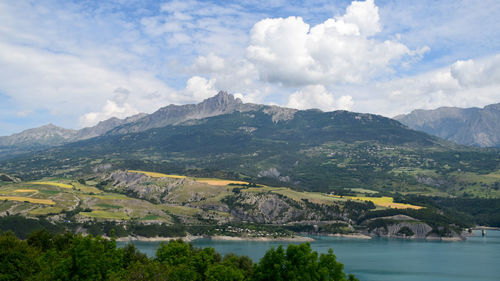 Scenic view of river and mountains against sky