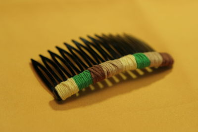 High angle view of colored pencils on table against yellow background