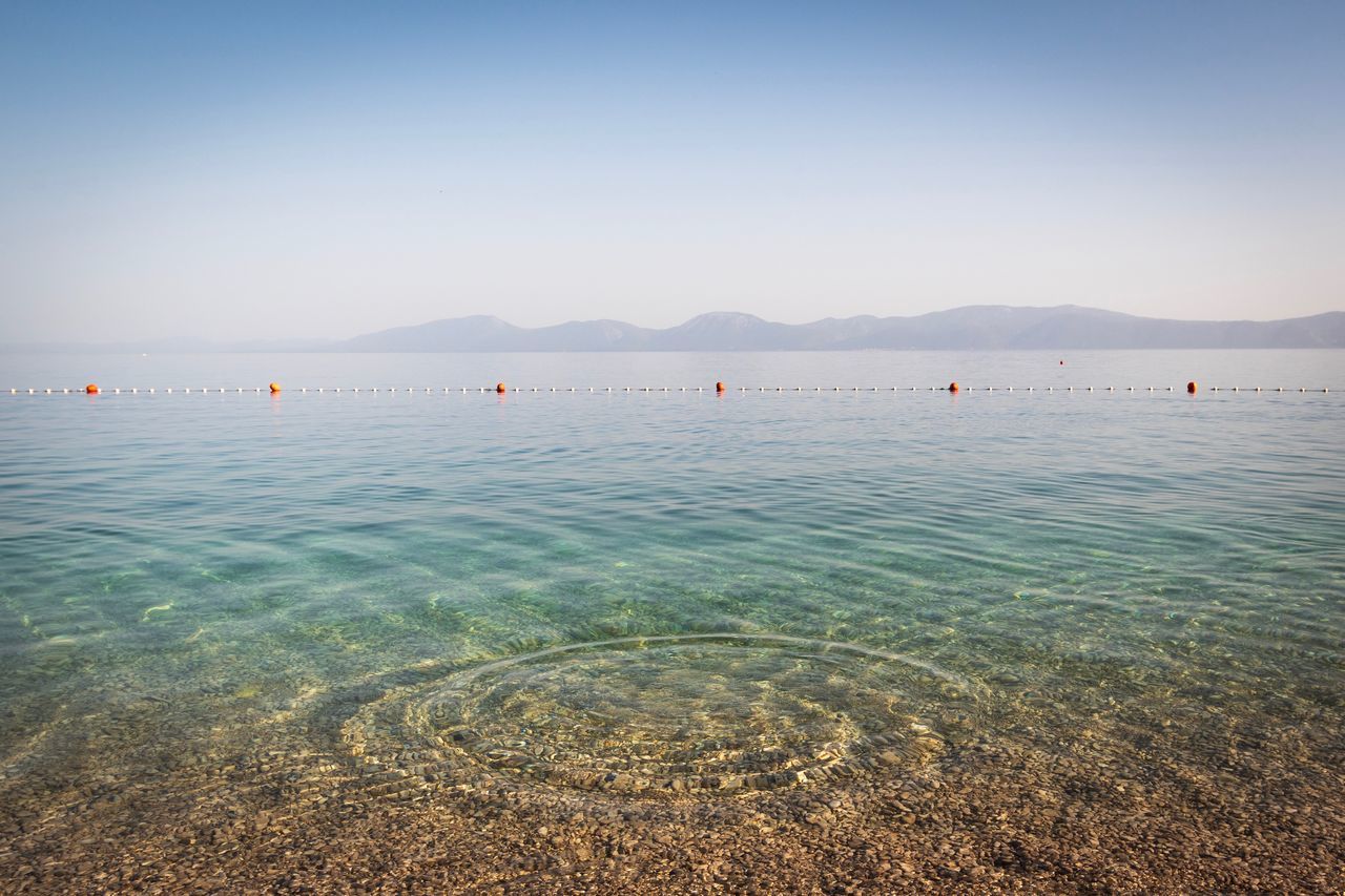 water, scenics - nature, beauty in nature, sky, sea, tranquil scene, tranquility, nature, waterfront, mountain, clear sky, idyllic, blue, day, copy space, land, beach, non-urban scene, no people, outdoors, shallow