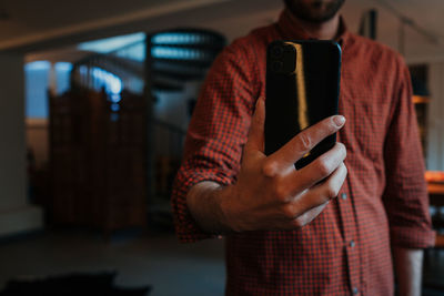 Midsection of man using mobile phone