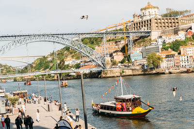 People on bridge over river in city