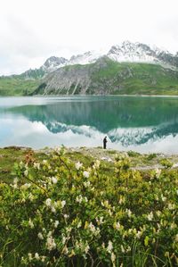 Scenic view of lake by mountains against sky