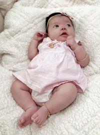 High angle view of baby girl lying on bed