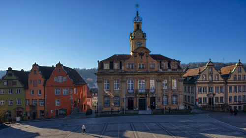 Buildings in city against clear blue sky