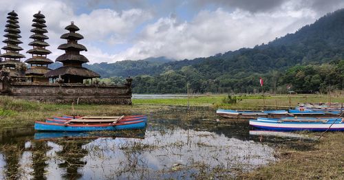 Boats moored on lake against sky
