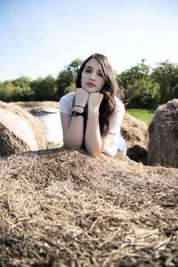 Portrait of beautiful young woman lying on field