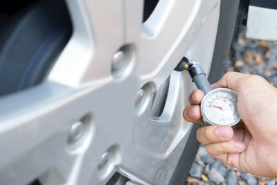 Close-up of mechanic hand measuring car tire