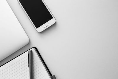 Close-up of mobile phone against white wall