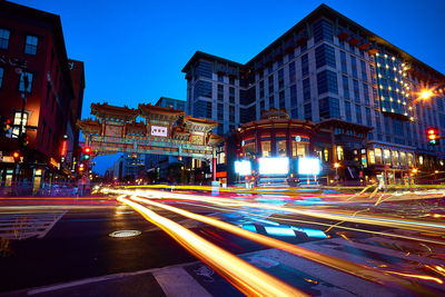Light trails on road along buildings at night