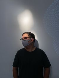 Portrait of young man looking away against white background