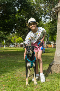 Portrait of man with dog on grassy field