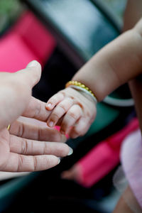 Close-up of woman holding baby hand