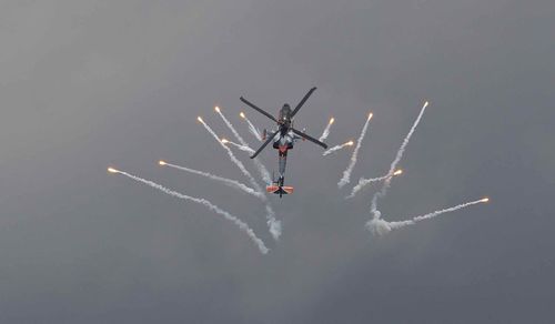 Low angle view of helicopter flying against sky