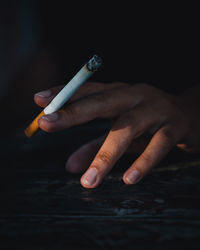 Cropped hand of person holding cigarette