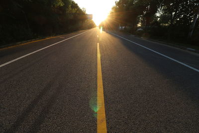 Road amidst trees at sunset