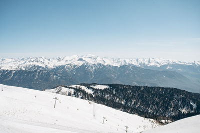 Scenic view of snow covered mountains against blue sky