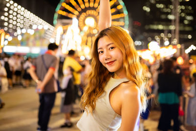 Portrait of smiling young woman at night