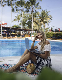 Portrait of young woman sitting in swimming pool