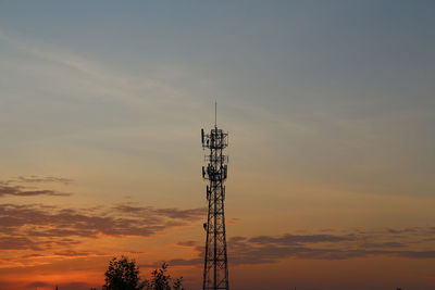 Low angle view of communications tower against sky during sunset