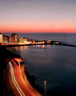 High angle view of illuminated city at sunset