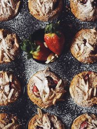 Directly above shot of cupcakes with strawberries in baking sheet