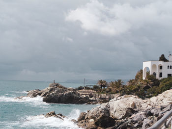 Scenic view of sea by buildings against sky