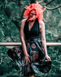 Full length portrait of young woman standing outdoors