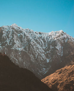 Scenic view of snowcapped mountains against clear blue sky