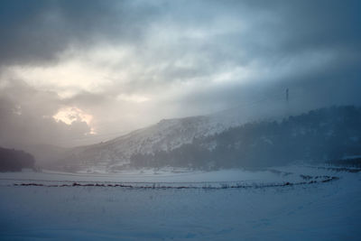 Snowy landscape where the sun's rays pass through deep clouds