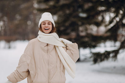 Portrait of young woman standing on snow