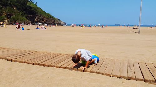 Boy playing on boardwalk at beach