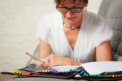 Midsection of woman holding eyeglasses