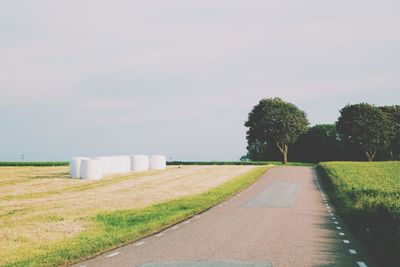 Hay bales on field against sky