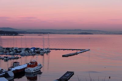 High angle view of boats moored at harbor during sunset