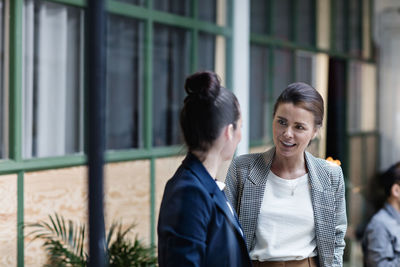 Businesswomen talking while standing at office