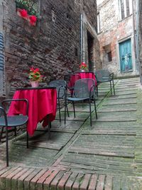 Red chairs on table against building