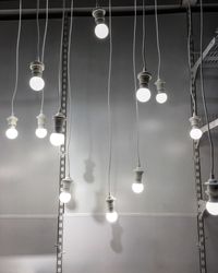 Illuminated light bulbs hanging against wall