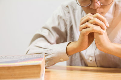 Midsection of man holding woman sitting on table