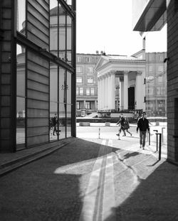 People walking on street amidst buildings in city