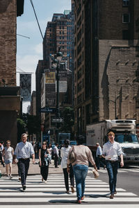 People walking on city street amidst buildings