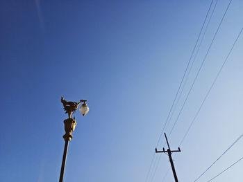 Low angle view of power lines against clear sky