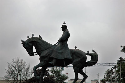 Low angle view of statue against sky