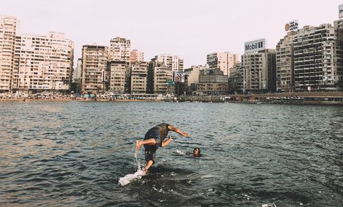 Man in sea against clear sky