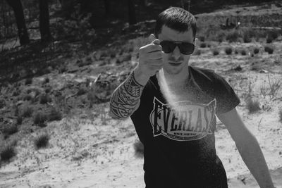 Portrait of young man wearing sunglasses standing outdoors