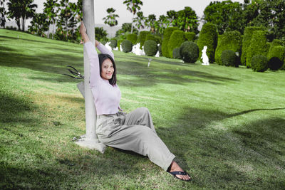 Man sitting on field by trees