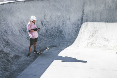 Sportsman using mobile phone at skateboard park