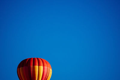 Cropped image of hot air balloon against clear blue sky