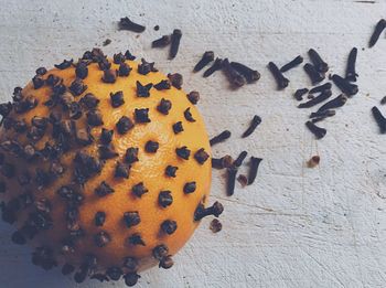 Directly above shot of orange studded with cloves on table