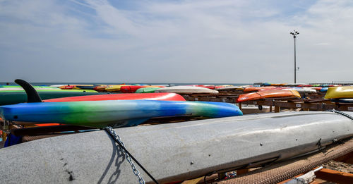 Boats moored in amusement park against blue sky